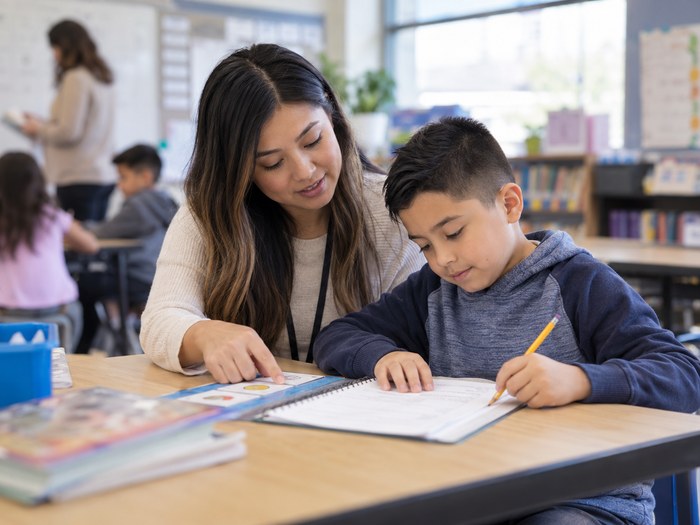 Behavior therapist supporting a child during a classroom activity.